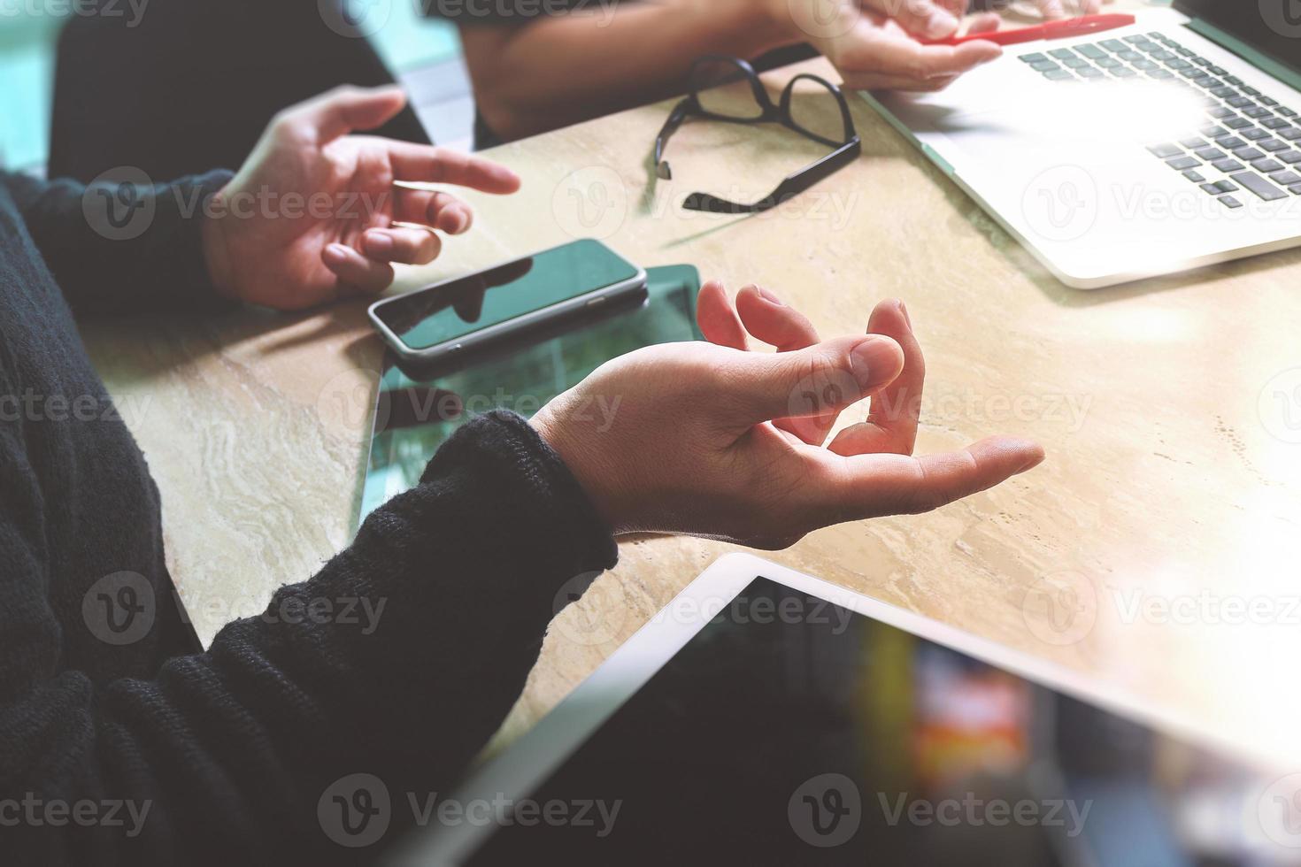 två kollega webbdesigner diskuterar data och digital surfplatta och dator bärbar dator med smart telefon och designdiagram på marmor skrivbord som koncept foto