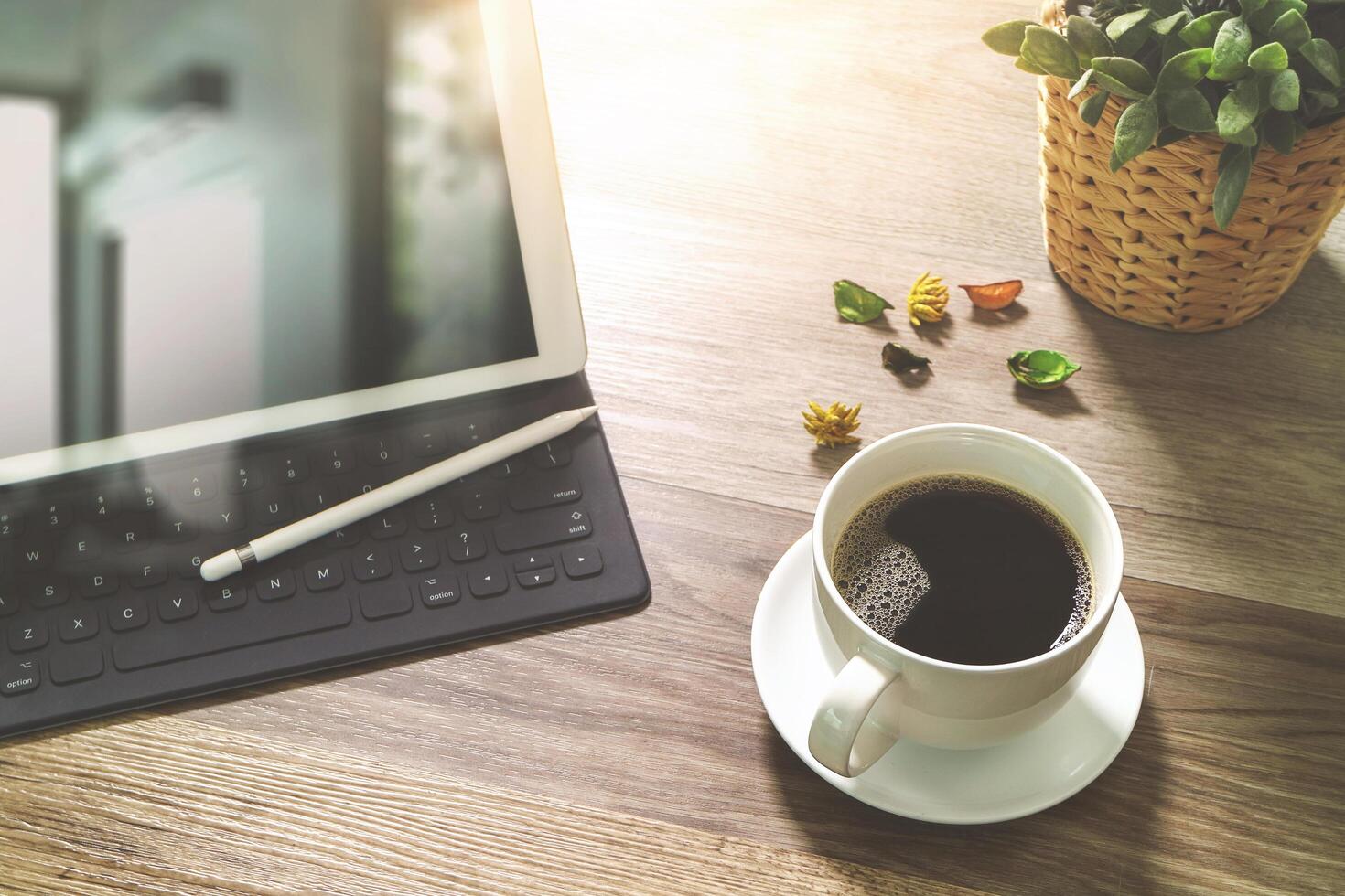 kaffekopp och digital bordsdocka smart tangentbord, vasblomma örter, penna på träbord, filtereffekt foto