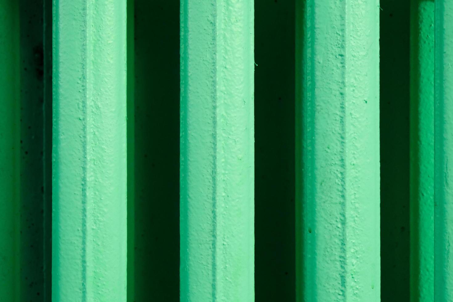 abstrakta vertikala ränder mönster från ett gammalt hemvärmebatteri tillverkat av gjutjärn och målat i grönt foto