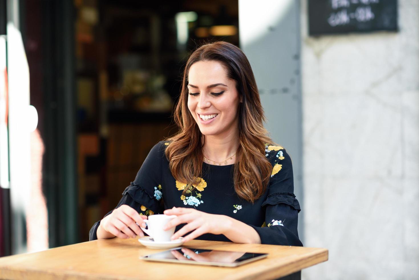 medelålders kvinna dricker kaffe i en urban cafébar. foto