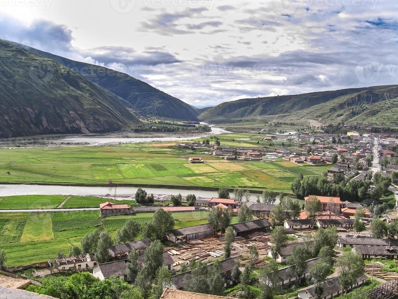 tibetansk by med hus och odlingsmark, resereportage foto