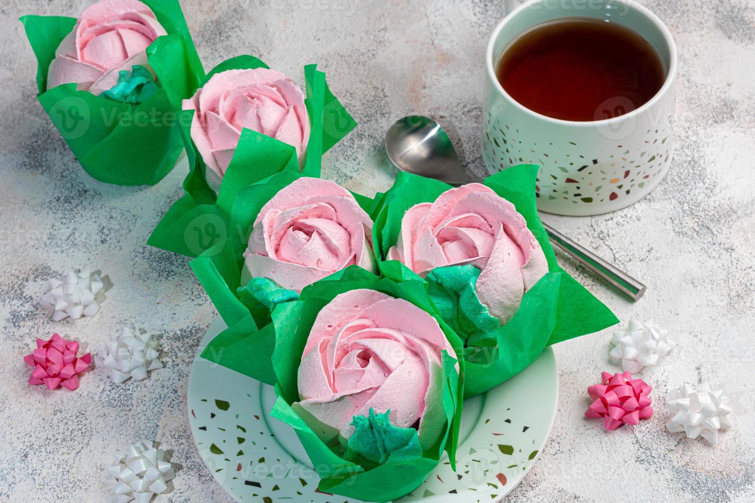 handgjorda marshmallows på en ljus bakgrund i form av rosor, hortensior och tulpaner. det finns blommor i närheten. kvinnodagen, alla hjärtans dag. foto