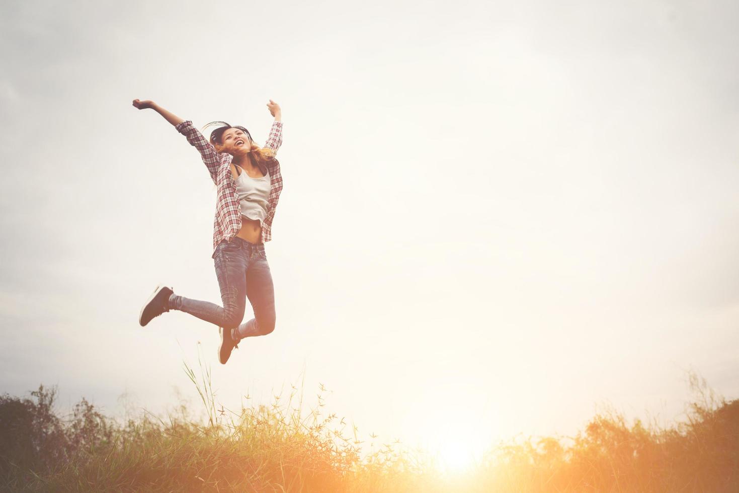 vacker hipster kvinna hoppa upp högt, frihet njuter med naturen runt. foto