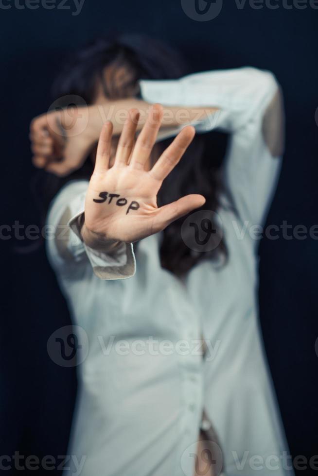 kvinna täcker hennes ansikte med handen med stoppskylt. foto
