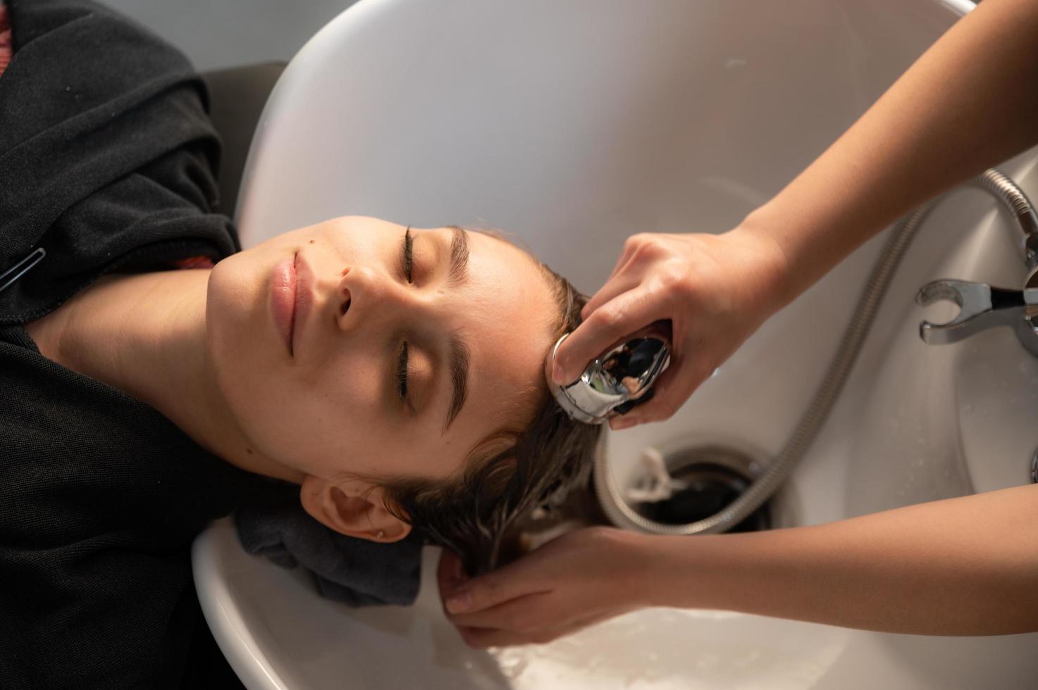 frisör och vacker klient kvinna gör behandling hår hälsovård i mode stil salong foto