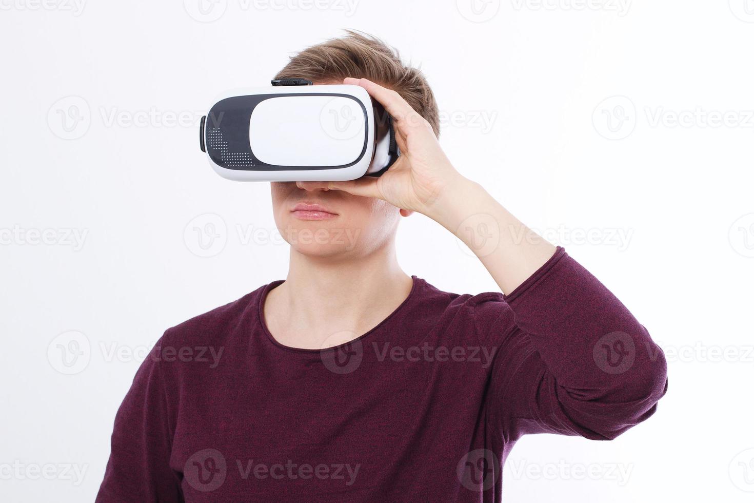 porträtt av ung man som bär virtuell verklighetsglasögon isolerad på vit bakgrund. kopiera utrymme och mock up. smartphone och vr-headset. horisontell bild foto