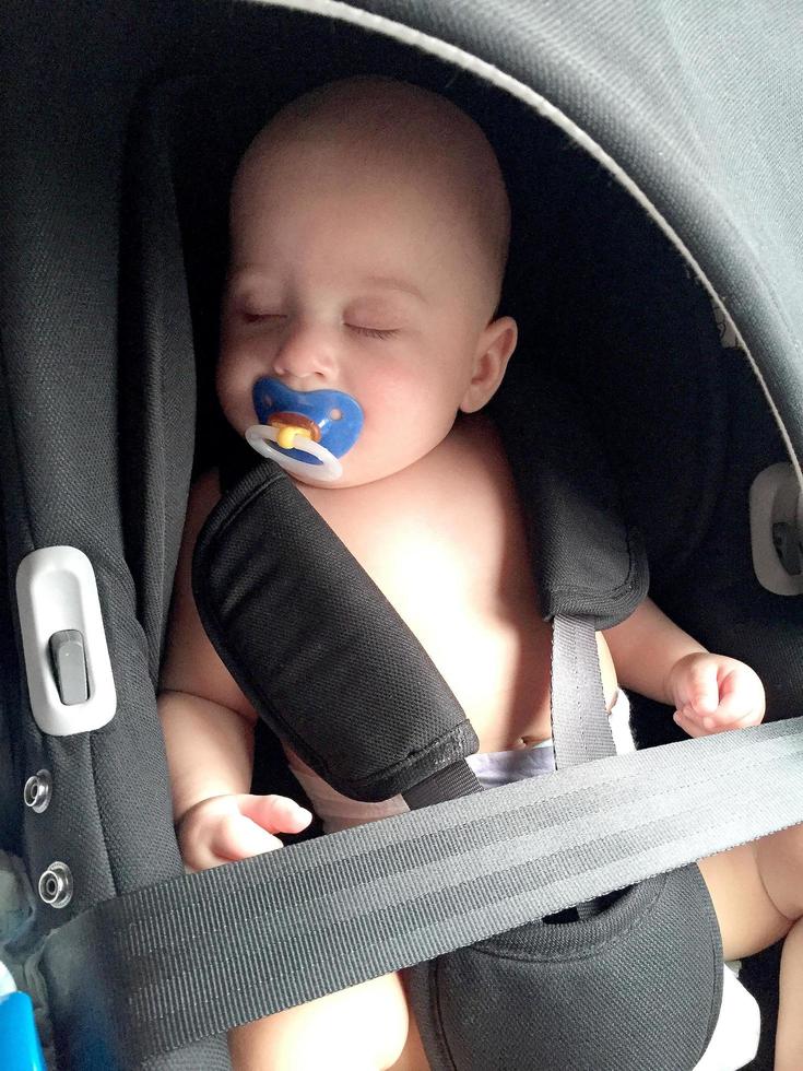 sovande pojke med napp poserar fotograf för färgfoto foto