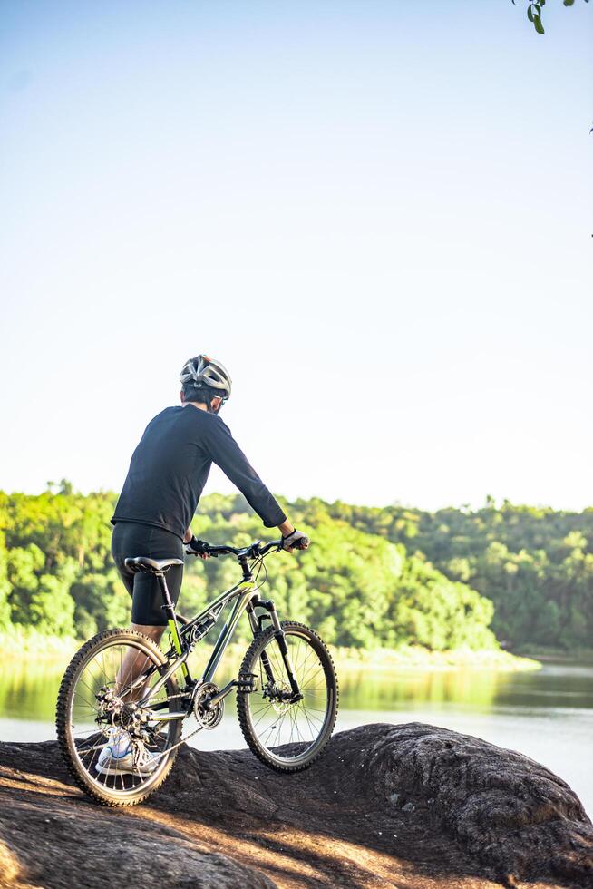 idrottare står på bergen med cykel foto