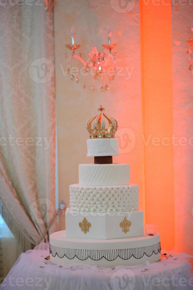bröllopstårta med lyx dekorerad i bröllopsfest. tårta dekorerad med krona foto