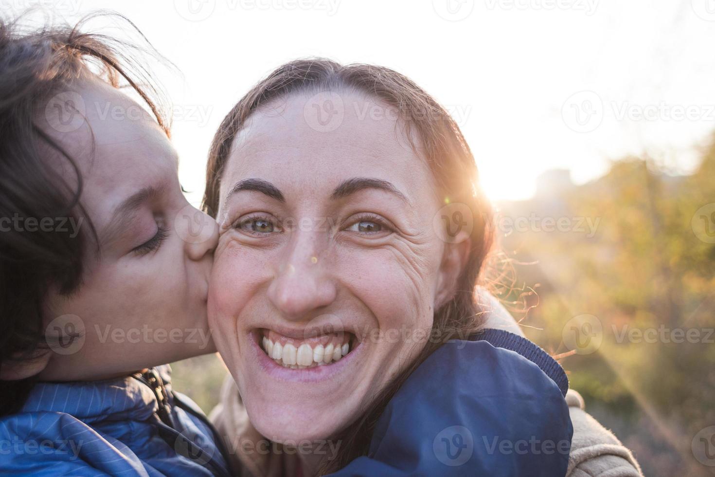 pojke pussar och kramar mamma, lyckligt moderskap foto