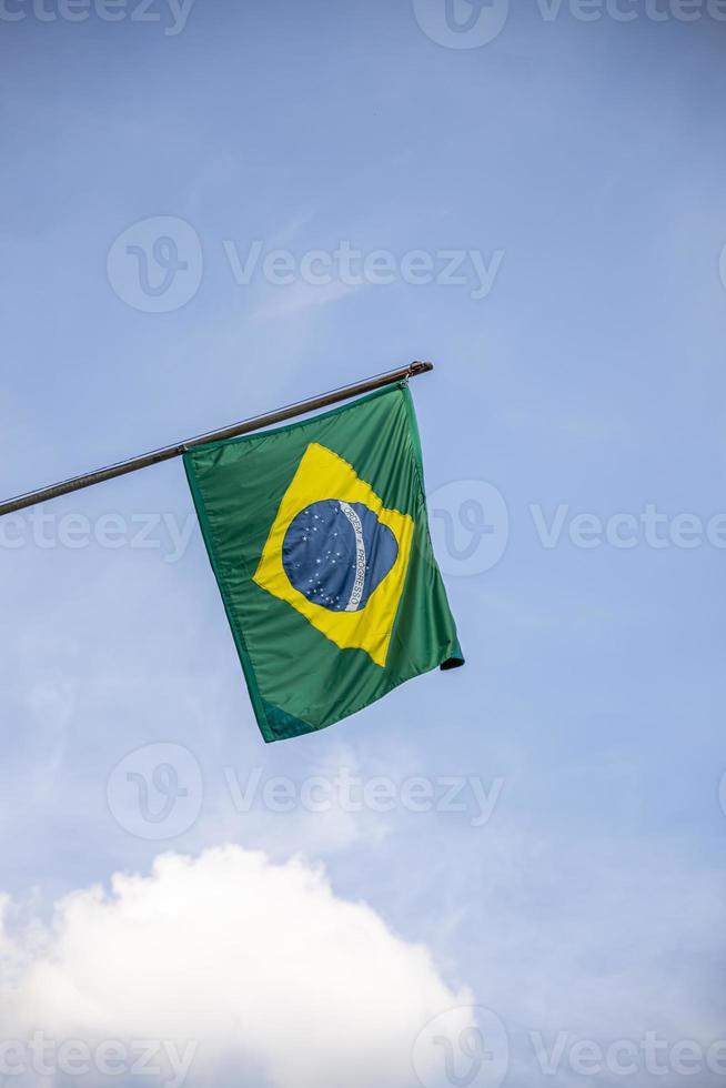 Brasiliens flagga. brasilianska flaggan visas på en stång framför huset. Brasiliens flagga vajar på ett hem som hänger från en stolpe på en ytterdörr till en byggnad. foto