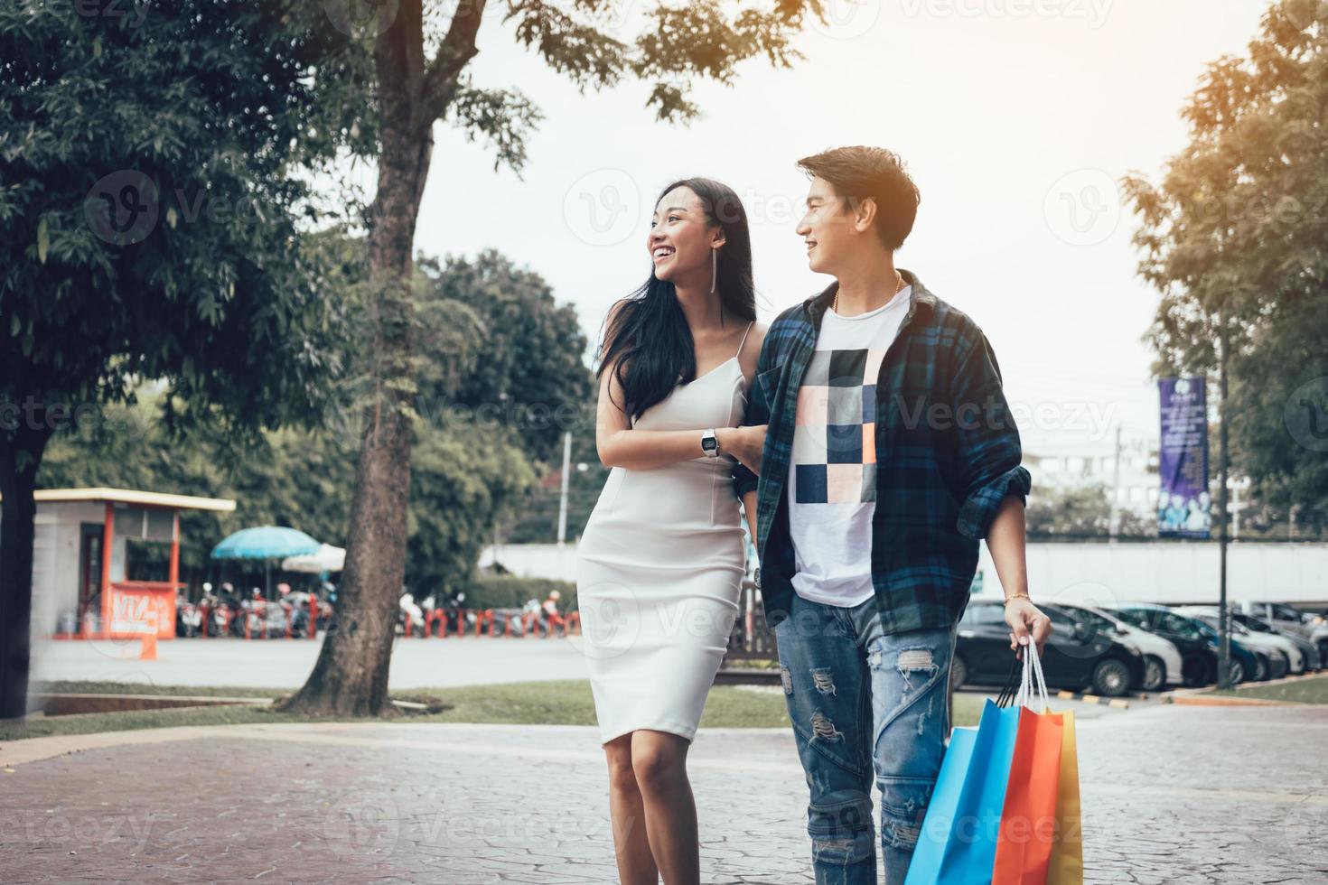 Asiatiska par går på köpcentrum ser produkten inuti spegel detaljhandeln. foto
