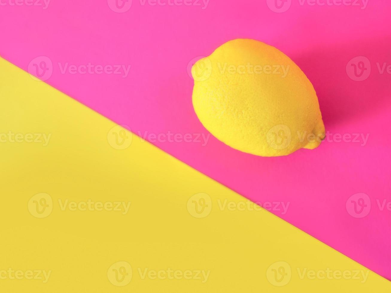 snygg gul citron på rosa och gul bakgrund. citrus, sommar, frukt koncept foto