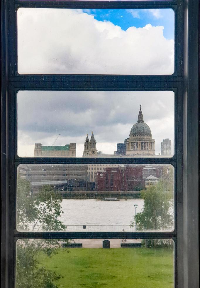 St Paul's Cathedral sett från ett tate modernt fönster en regnig dag foto