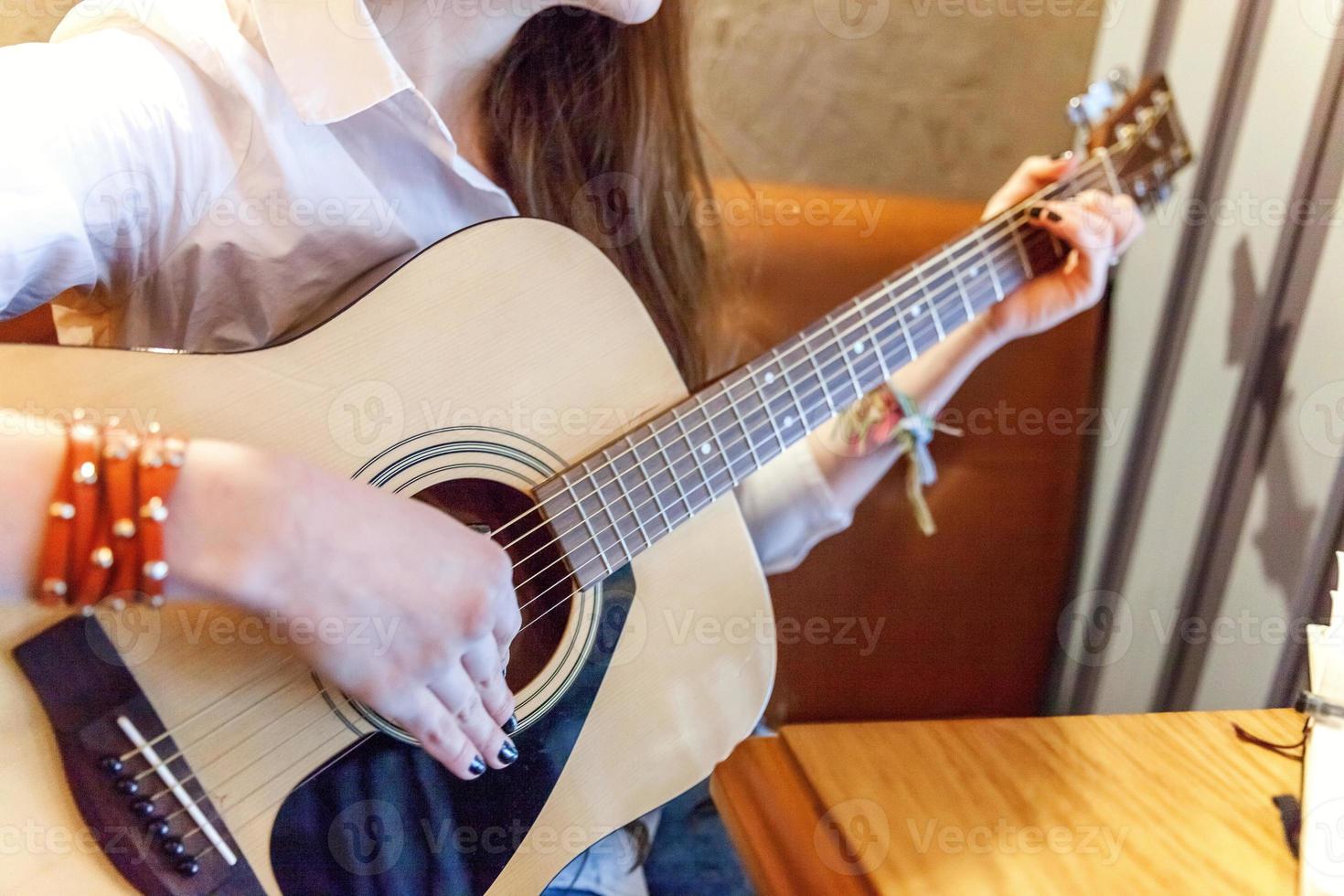 ung kvinna som spelar gitarr foto