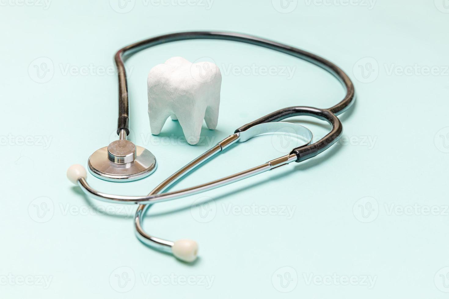 hälsotandvård koncept. medicin utrustning stetoskop vit frisk tand isolerad på pastellblå bakgrund. instrumentanordning för tandläkare. tand munhygien, tandläkardag. foto