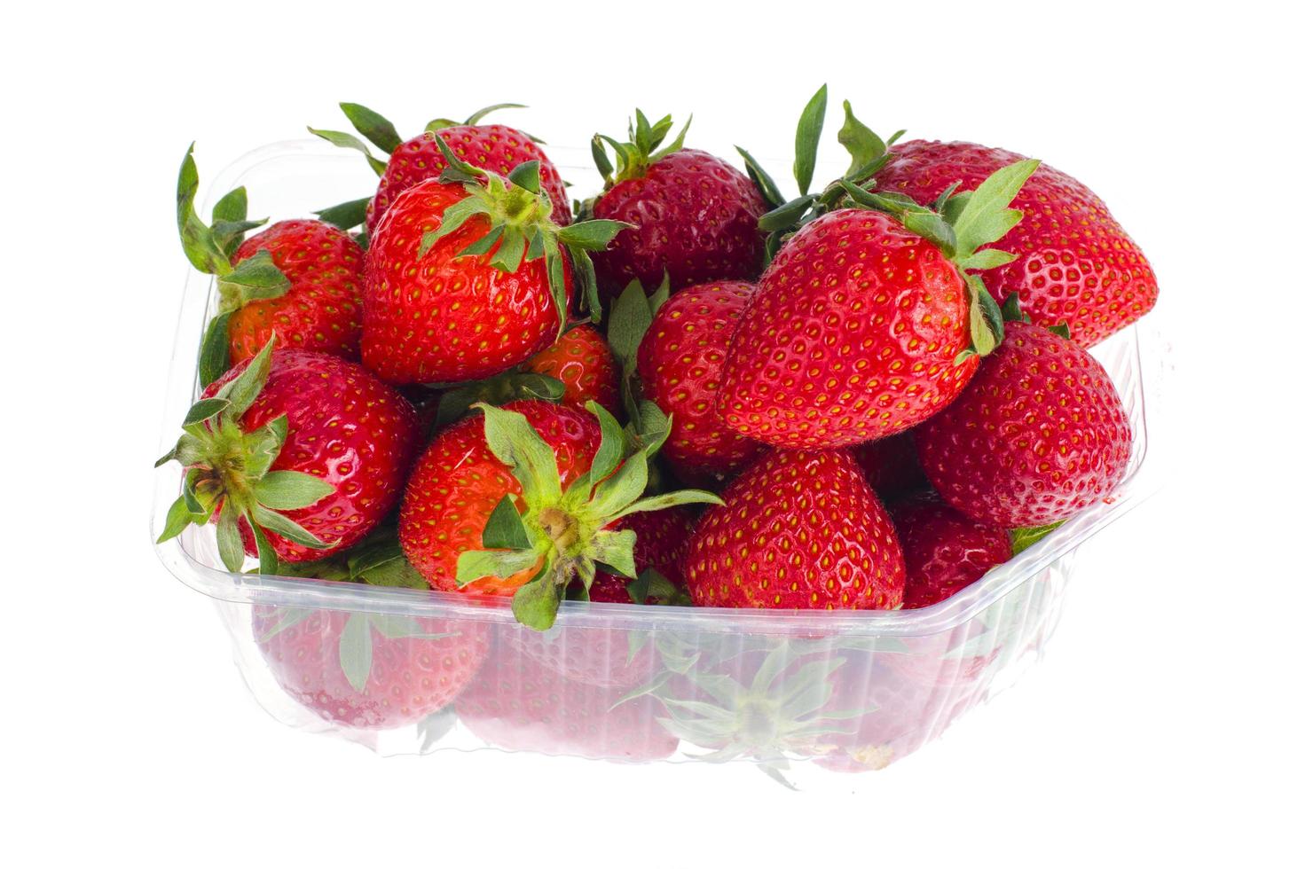 färska söta röda jordgubbar i plastbehållare. foto