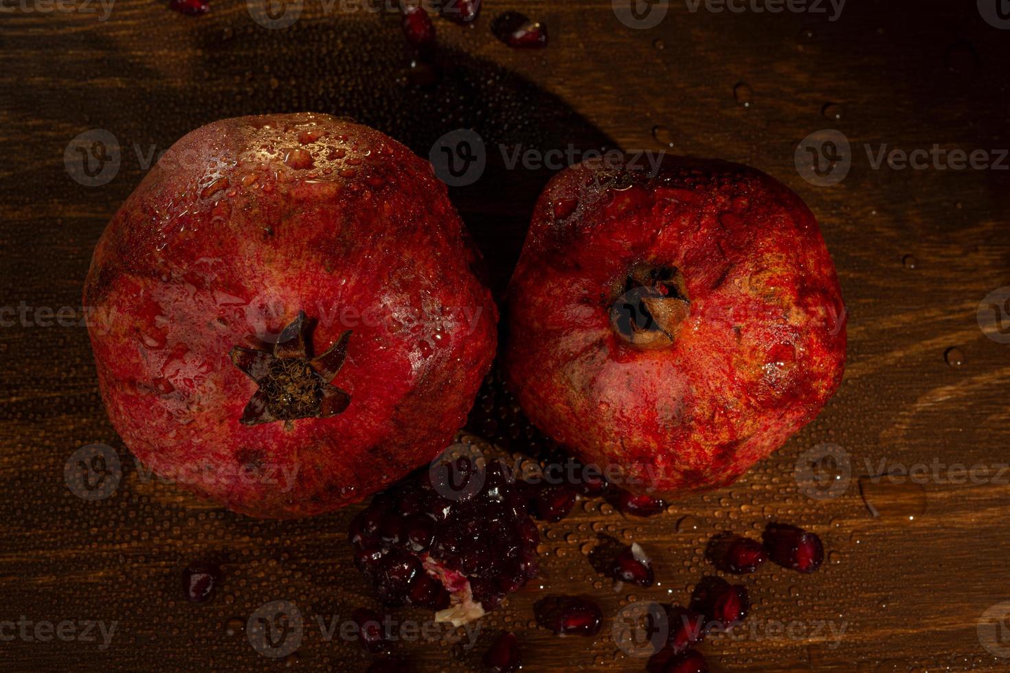 rött moget vått granatäpple på bordet. närbild foto