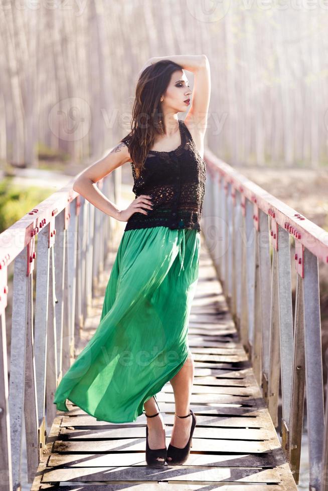 kvinna som bär lång klänning i en lantlig bro foto