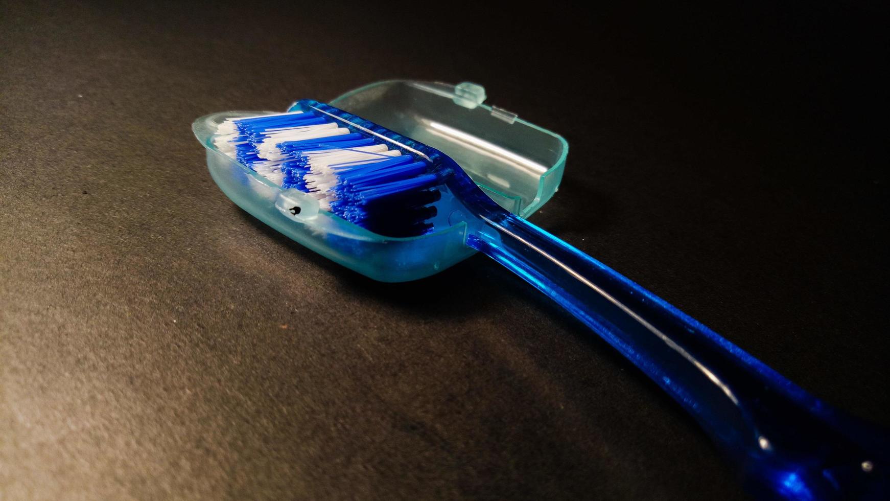 blå tandborste på svart bakgrund foto