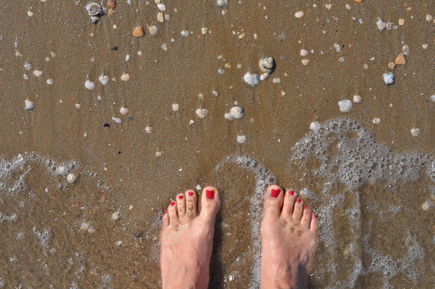 kvinnliga fötter på stranden foto
