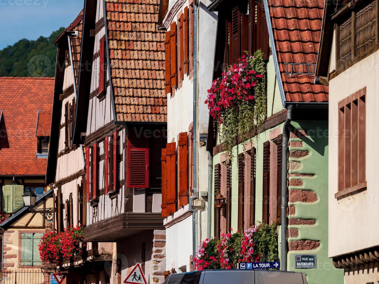 klassiska alsace-fönster i ett korsvirkeshus, dekorerat med träsniderier och blommor foto