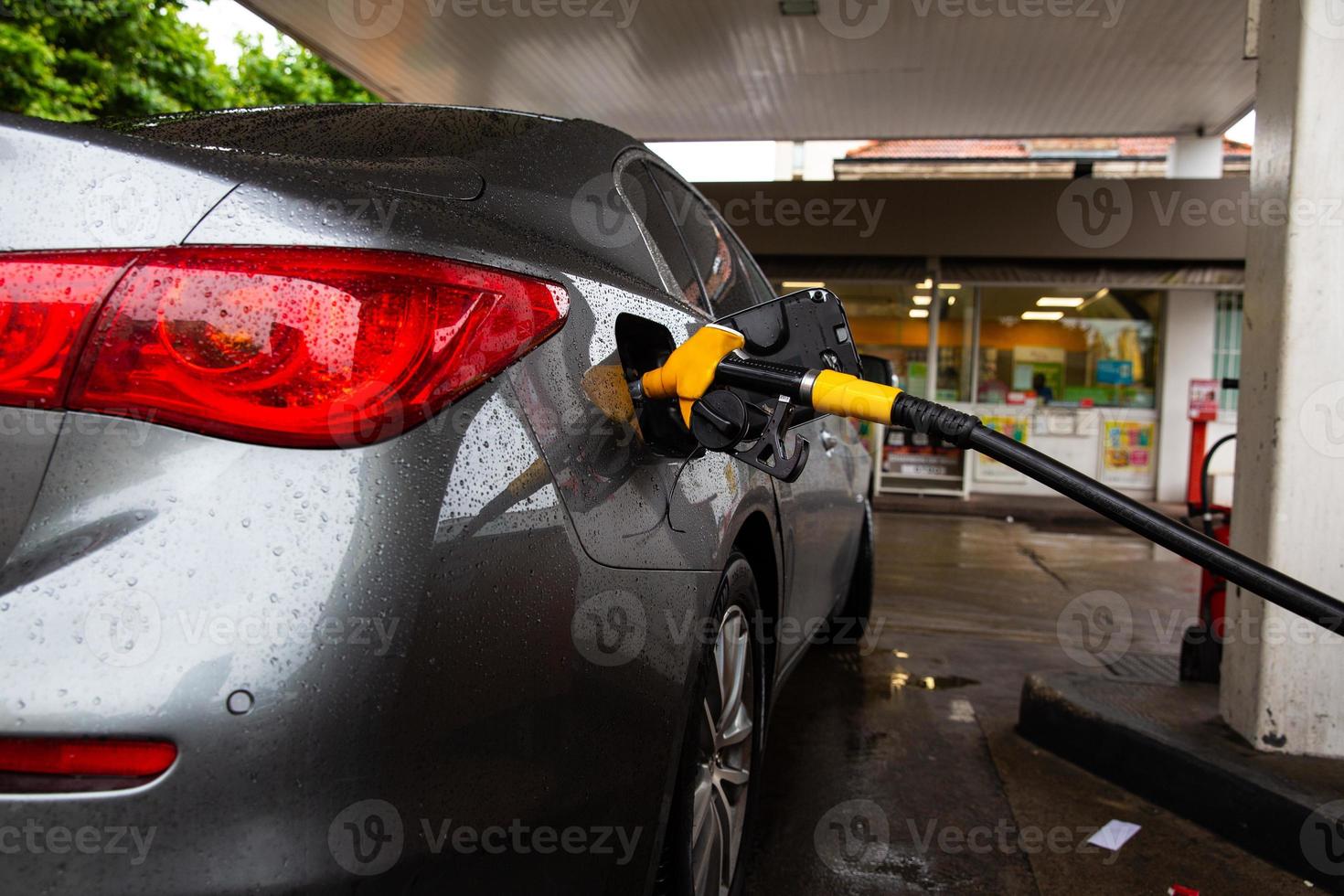 bil tankning bränsle på bensinstation. tjänsten fyller gas eller biodiesel i tanken. foto