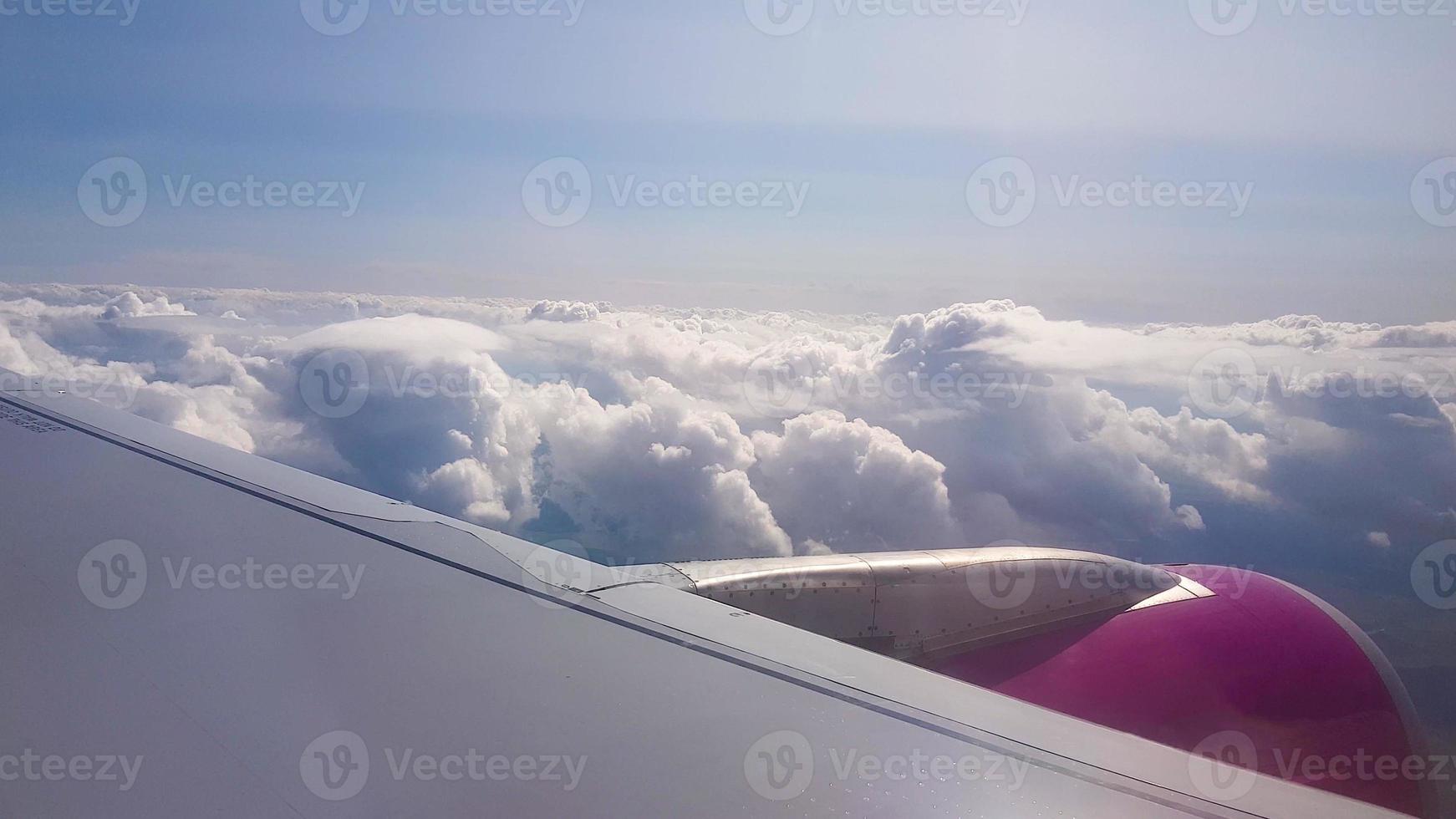 flyger över molnen. utsikt från flygplanspassagerarfönster med moln och horisont. foto