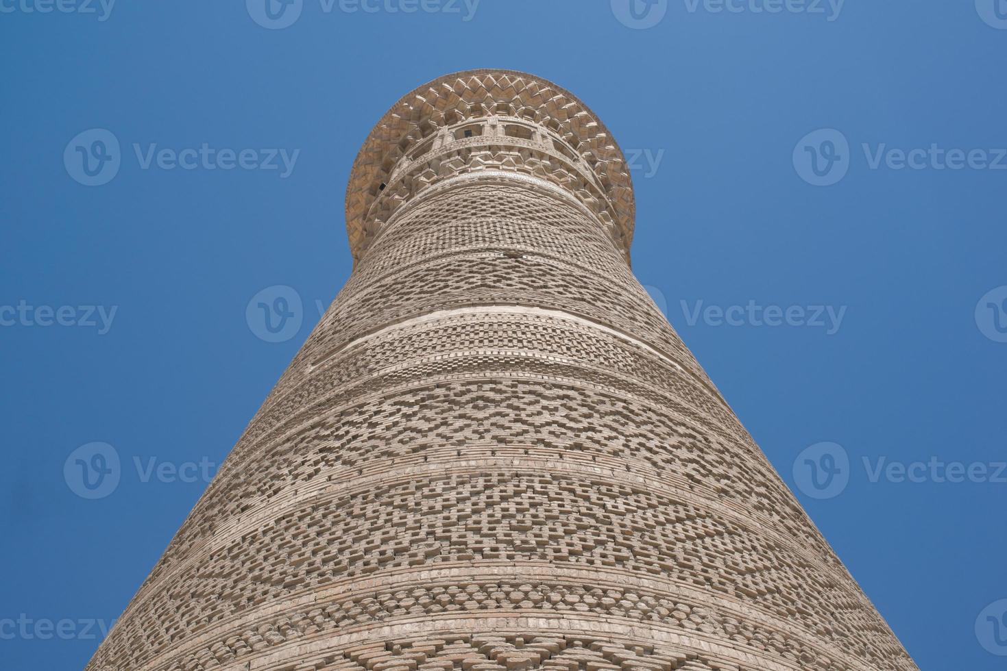 högt ovalt torn av tegel, gamla asiatiska byggnader. detaljerna i arkitekturen i medeltida centralasien foto