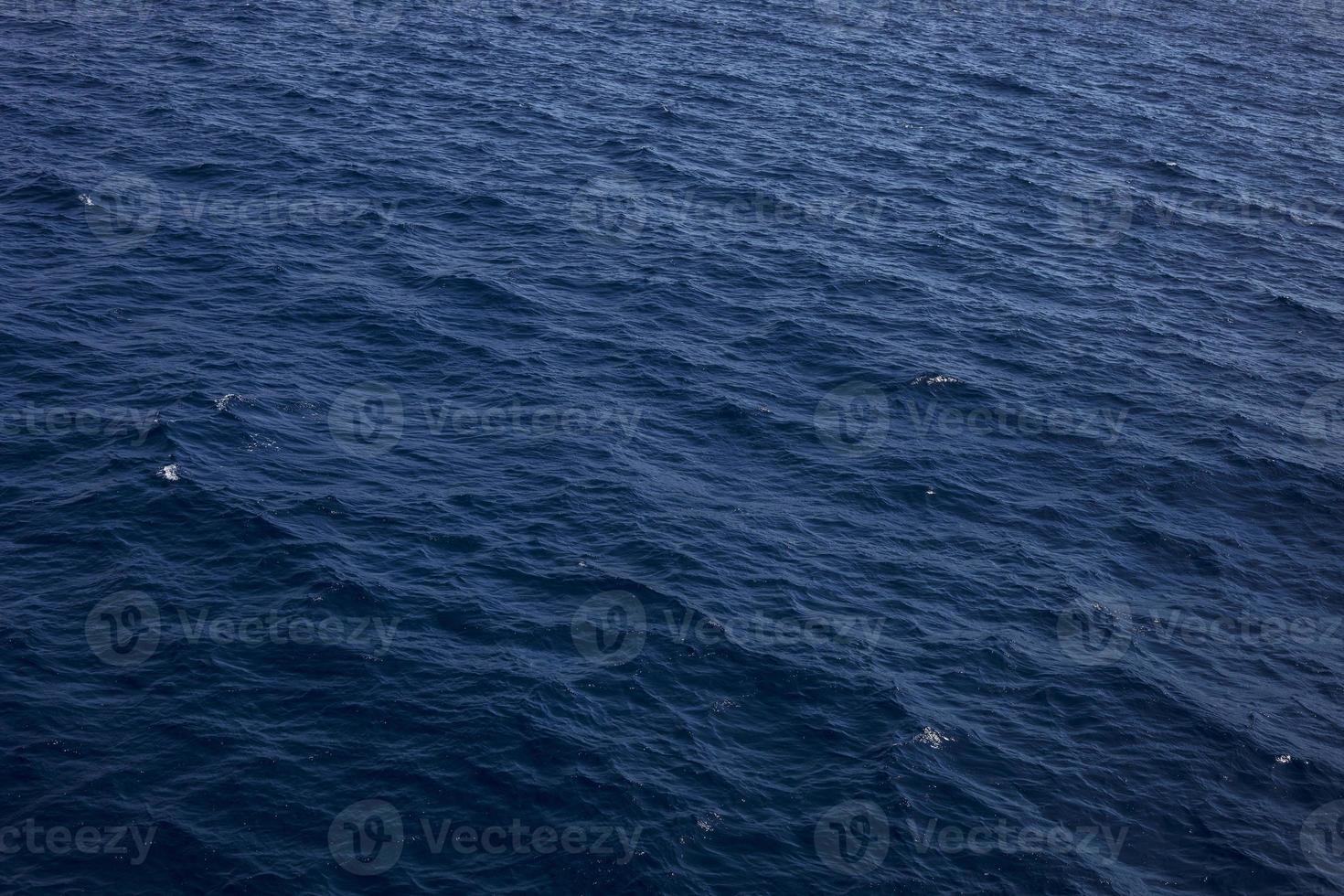 blå toner vattenvågor ytan som bakgrund. havsvatten textur. grunder är ytan av vattenflödet från flödet av vatten för att konvergera. foto
