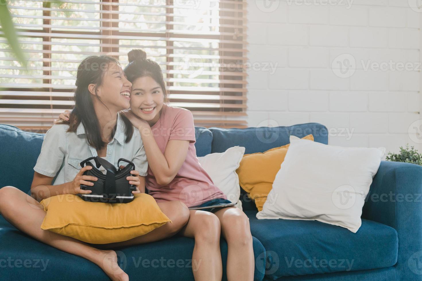 unga lesbiska lgbtq asiatiska kvinnor par som använder surfplatta hemma, asiatisk älskare kvinnlig känsla glad roligt och virtuell verklighet, vr spelar spel tillsammans medan liggande soffa i vardagsrummet hemma koncept. foto