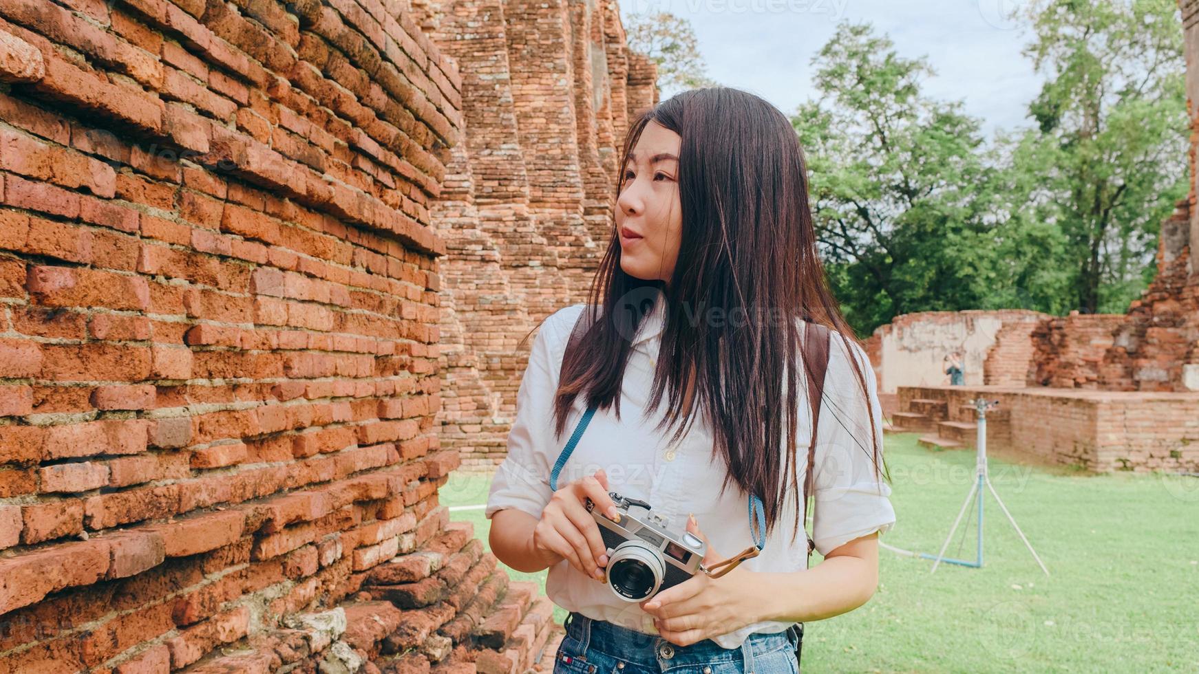 resenär asiatisk kvinna tillbringar semesterresa i ayutthaya, thailand, japansk backpacker-kvinna, njut av sin resa vid ett fantastiskt landmärke i en traditionell stad. livsstil kvinnor reser semester koncept. foto