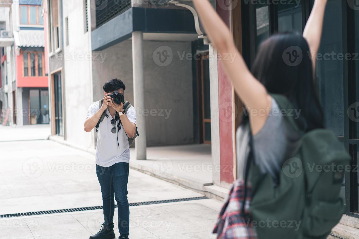 resenär asiatiskt par reser i Peking, Kina, söta par som använder kameran som fotograferar varandra nära gatan medan de tillbringar semesterresan. livsstil par resor i staden koncept. foto