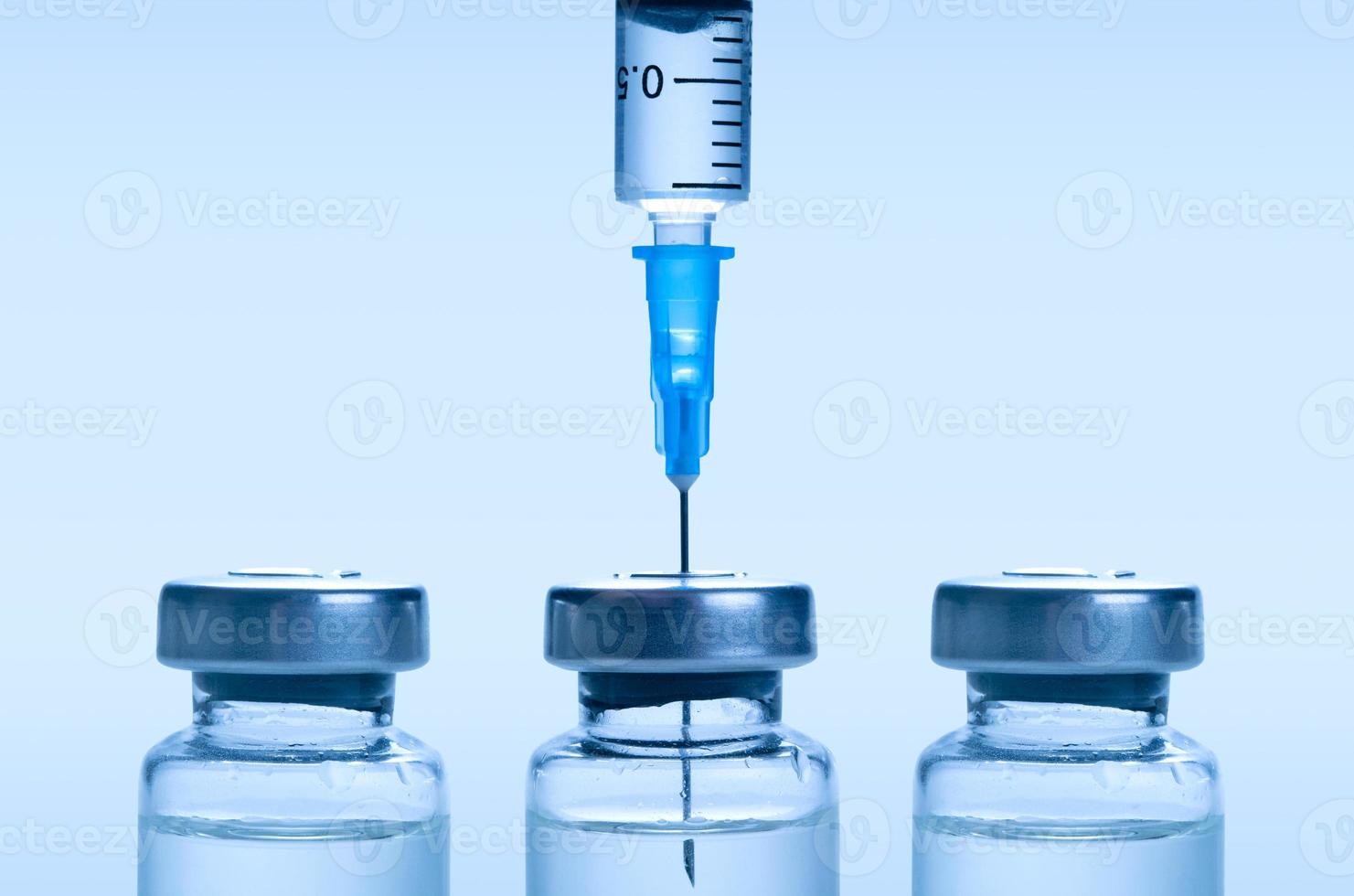 medicinsk spruta med en nål och en bollte med vaccin. foto