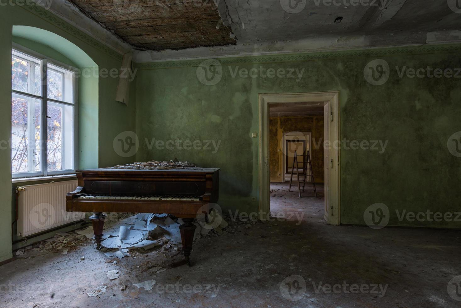 grönt rum med ett piano i ett gammalt hus foto