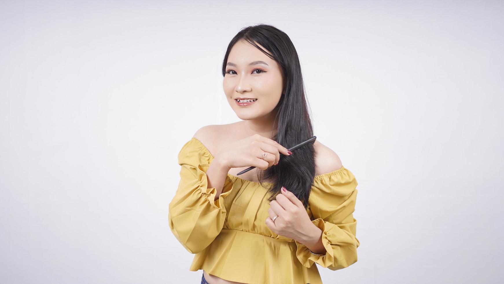 asiatisk flicka klä upp kamma håret isolerad på vit bakgrund foto