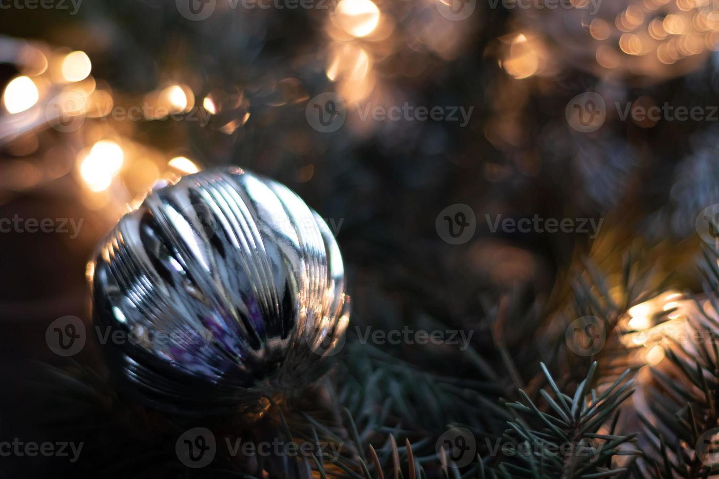 julleksaker, silverkulor på julgransgren. bokeh bakgrund med krans. kopieringsutrymme foto