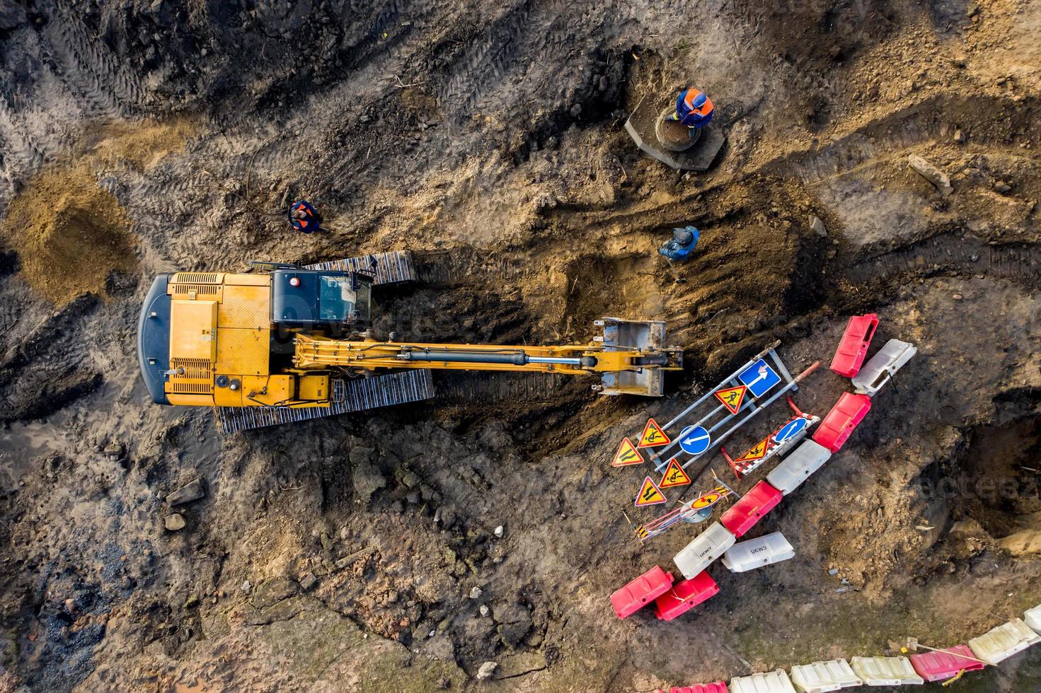 ovanifrån från luften på bandgrävmaskinens grävningsmark för översyn av vägen. entreprenadmaskiner utför energikrävande tungt arbete på projekt foto