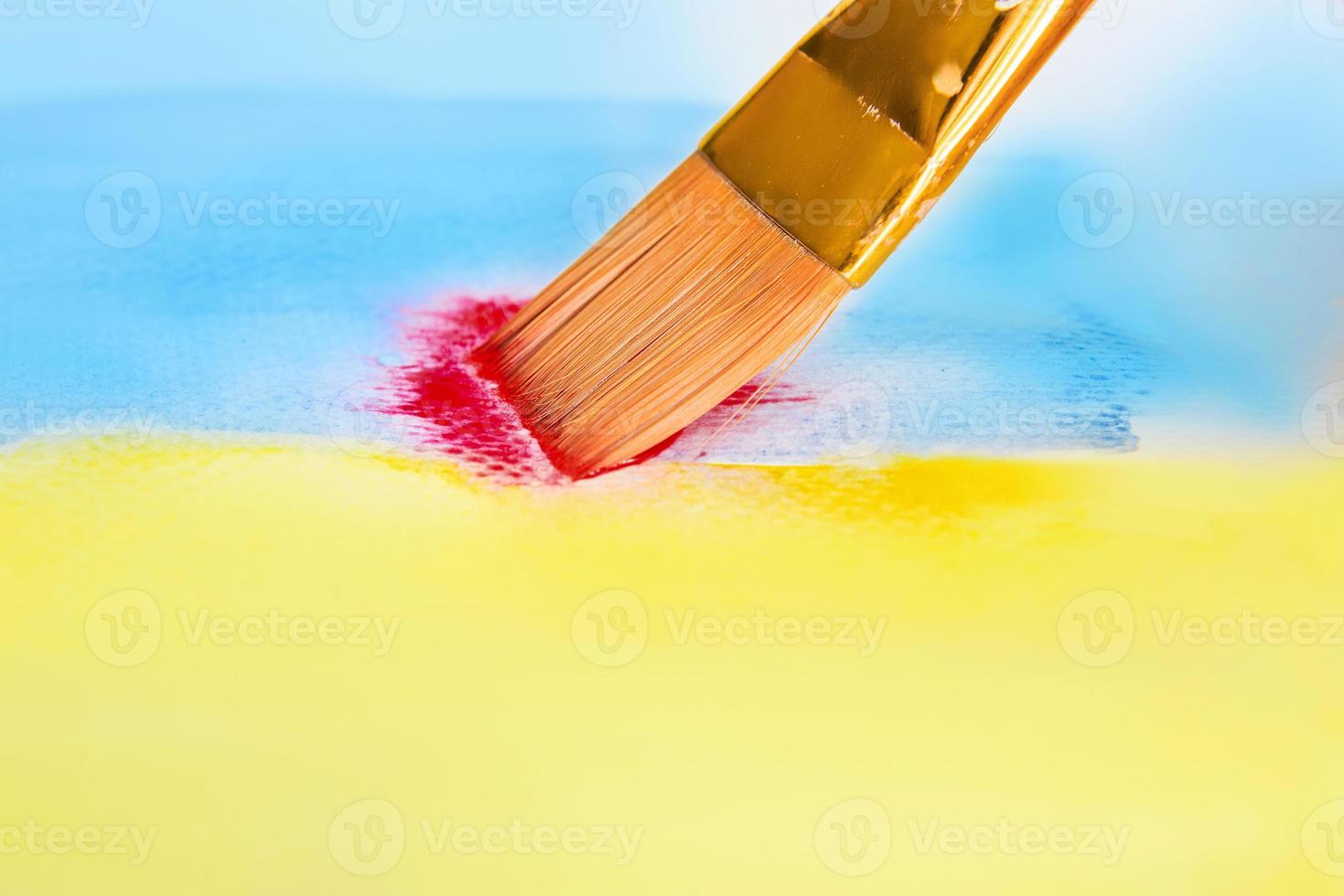 pensel med blå och gul och röd akvarellfärg foto