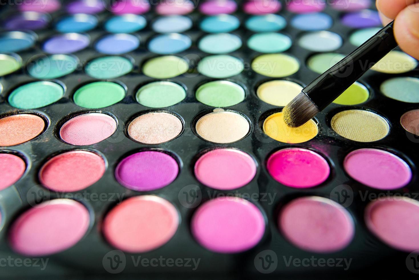 palett av färgglada ögonskuggor och sminkborste foto