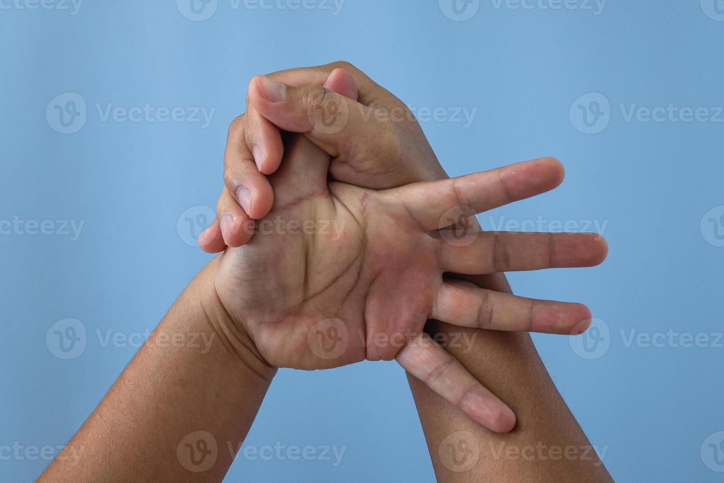 office syndrom koncept. tumfingret masseras och sträcks ut efter arbetet. närbild skott isolera på blå bakgrund. förhandsvy. foto