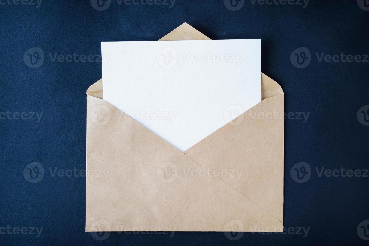 tomt vitt kort i brunt kuvert på mörk bakgrund foto