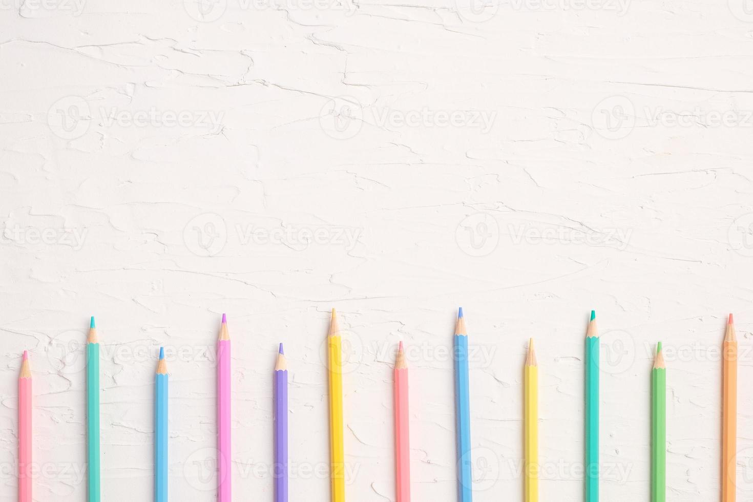 ovanifrån av pastellfärg penna och fil på vitt bord foto