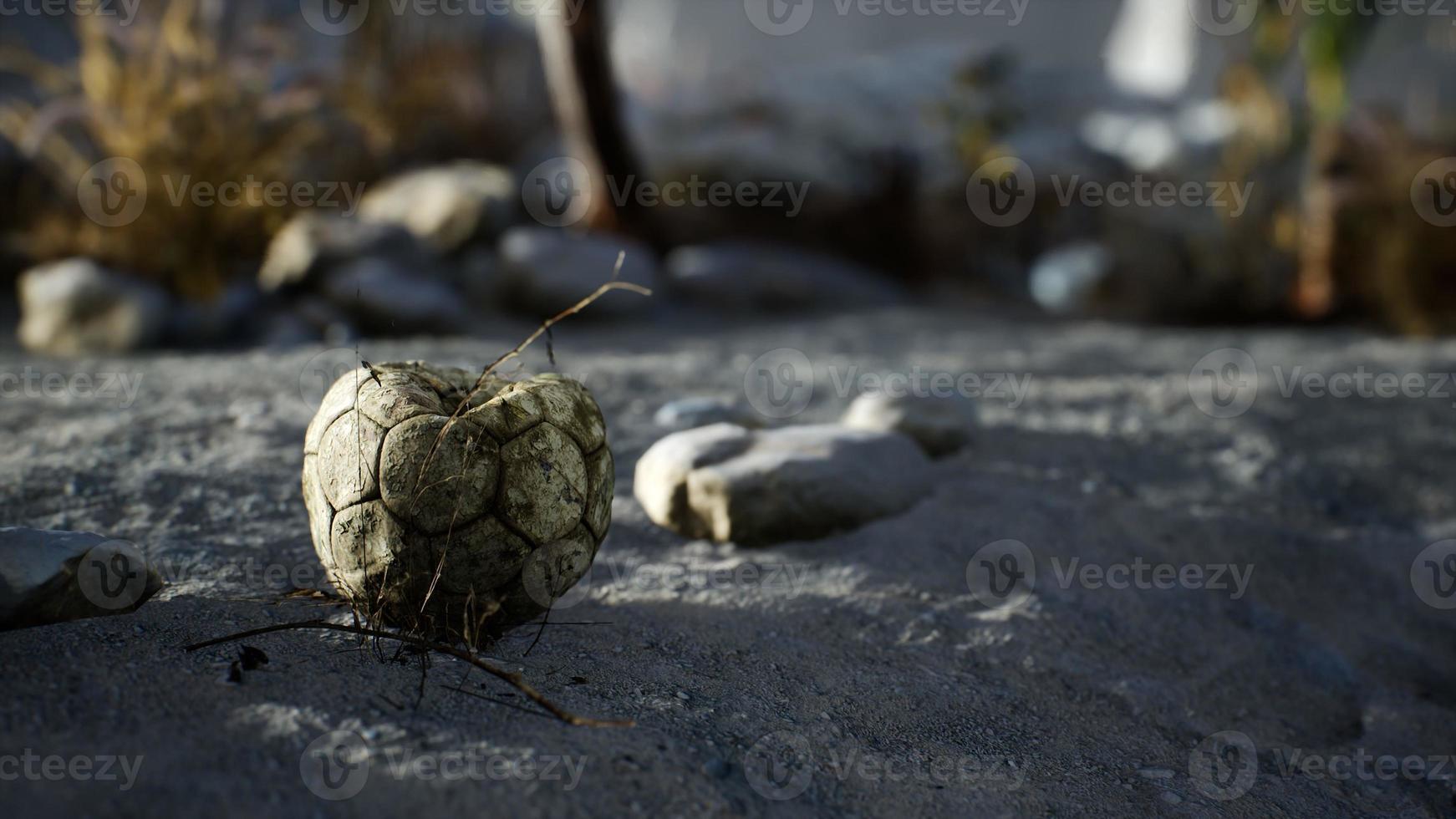 en gammal sönderriven fotboll som kastas ligger på havsstranden foto