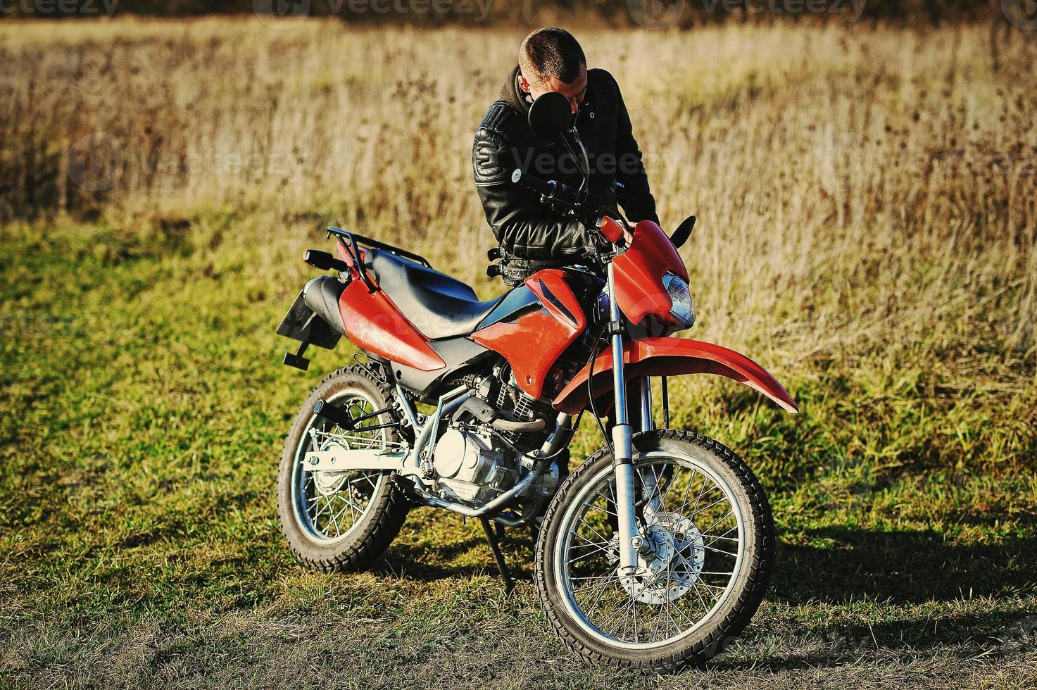 motorcykelförare stanna i solnedgången med sin endurocykel foto