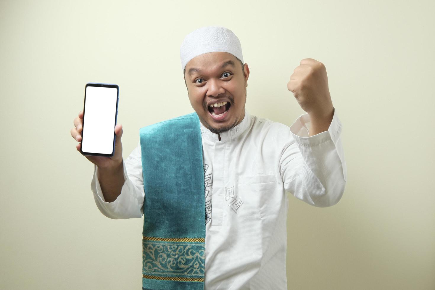 feta asiatiska muslimska män ser förvånade över de goda nyheterna på telefonen foto