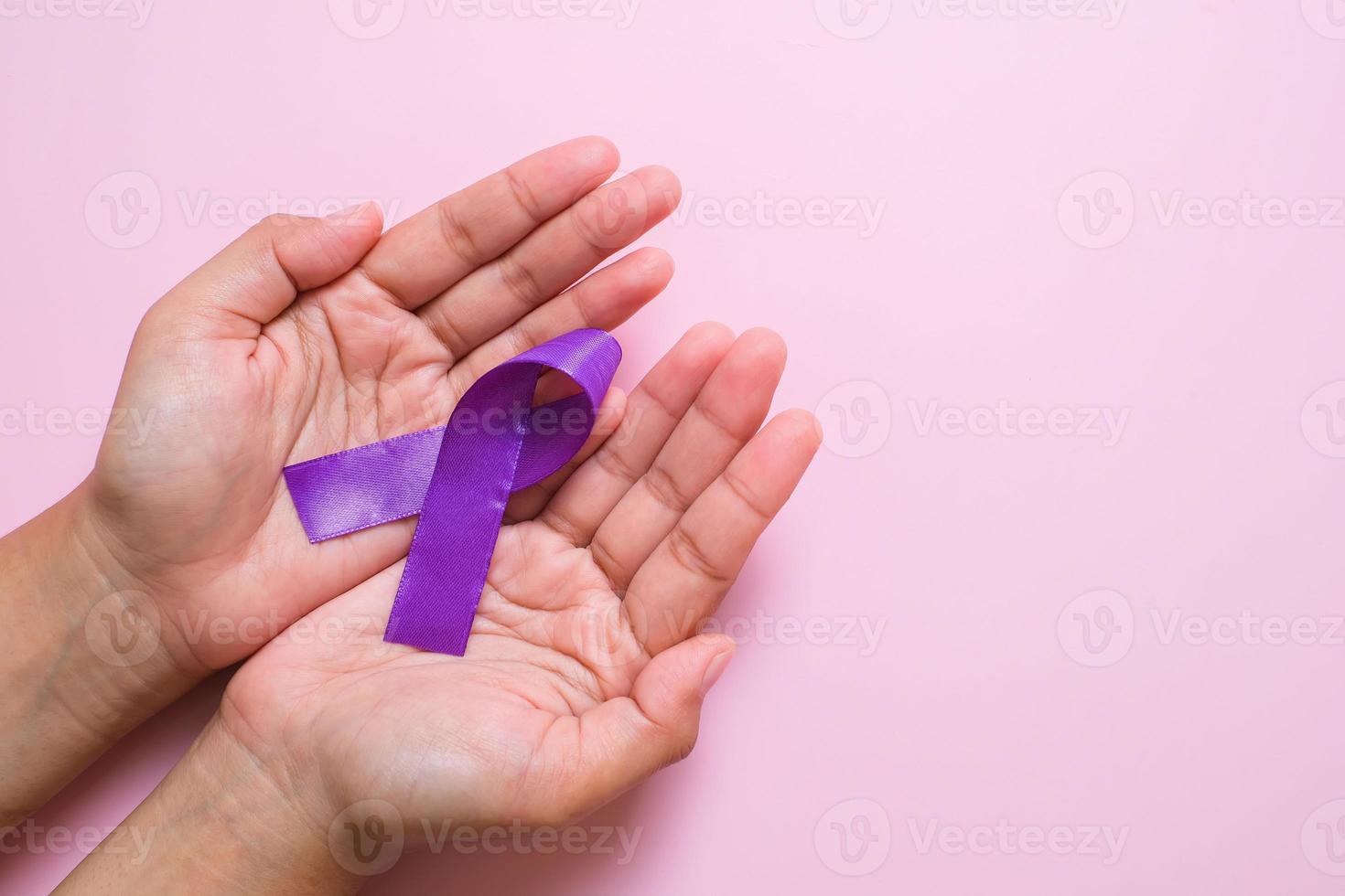 händer som håller lila band världen cancer dag koncept foto