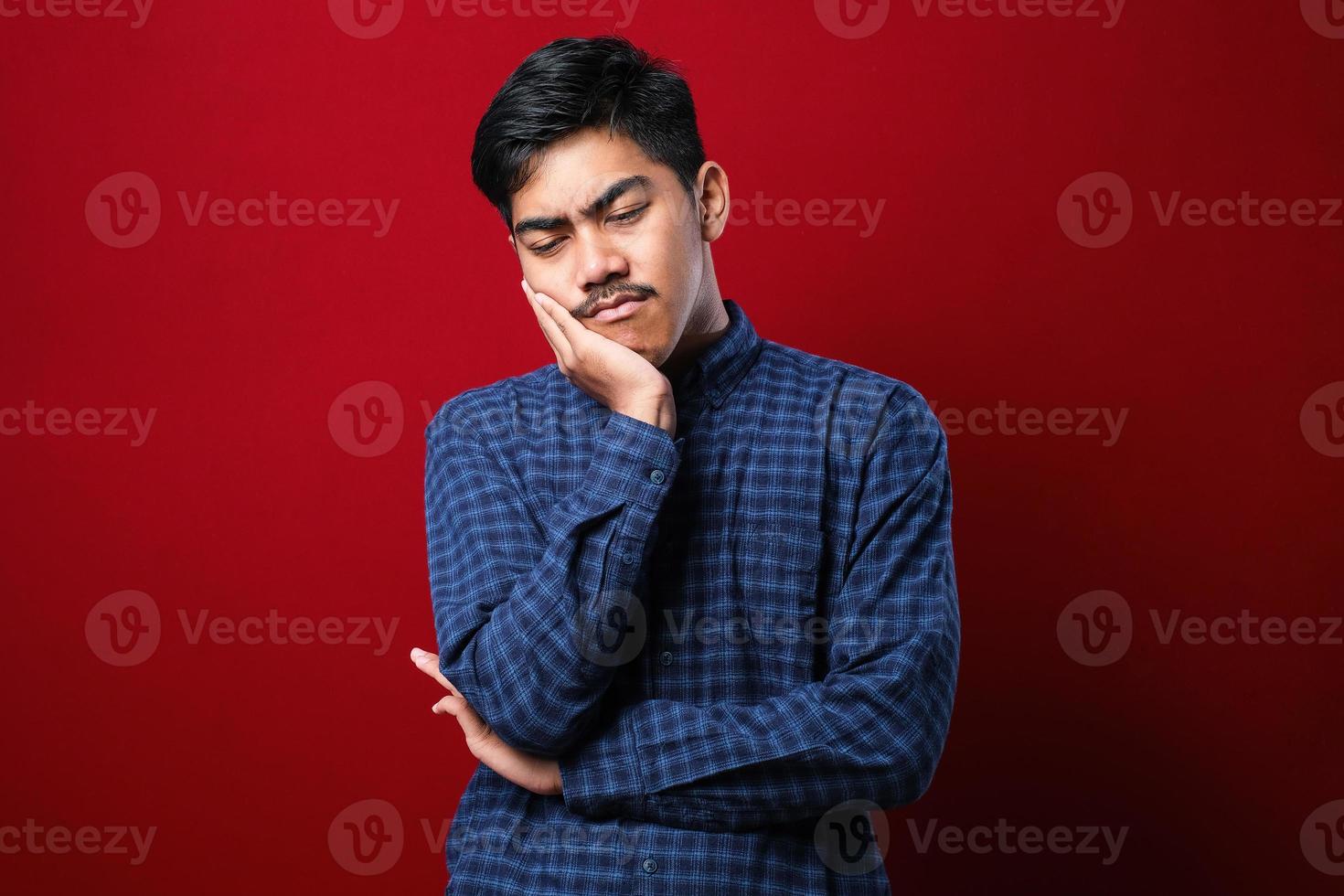 ung asiatisk man bär casual skjorta tänker ser trött och uttråkad med depression problem med korsade armar. foto