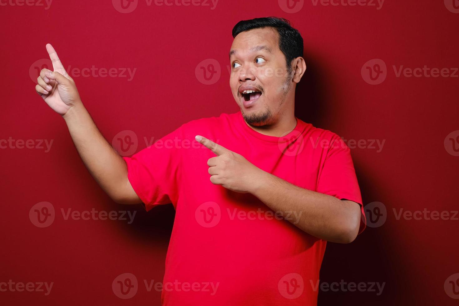 asiatisk man ler till kameran medan han presenterar något på sin sida med kopia utrymme foto