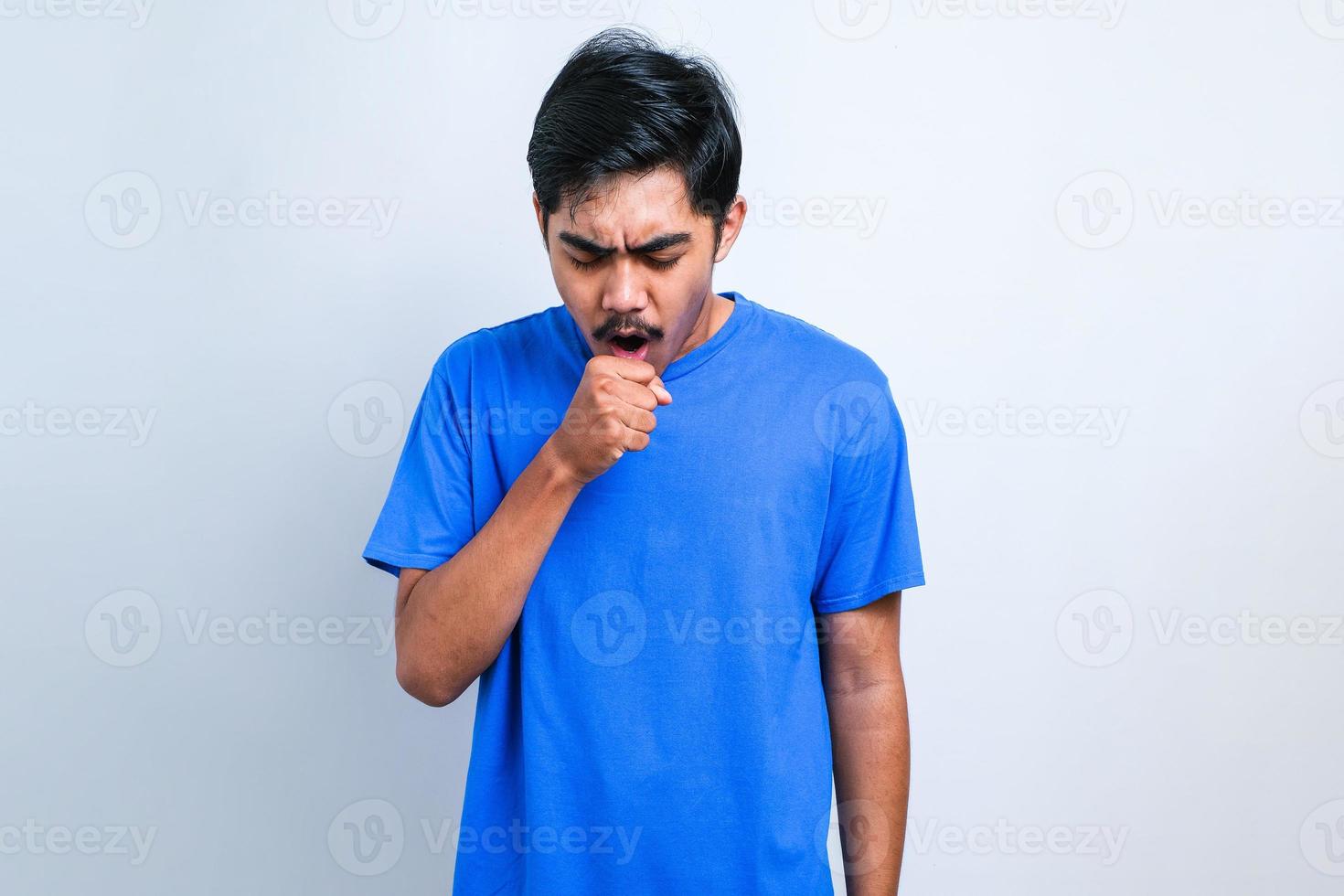 ung asiatisk man hostar med ont i halsen foto
